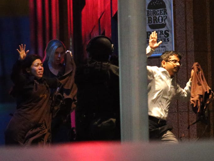 Free hostages run towards police from a cafe under