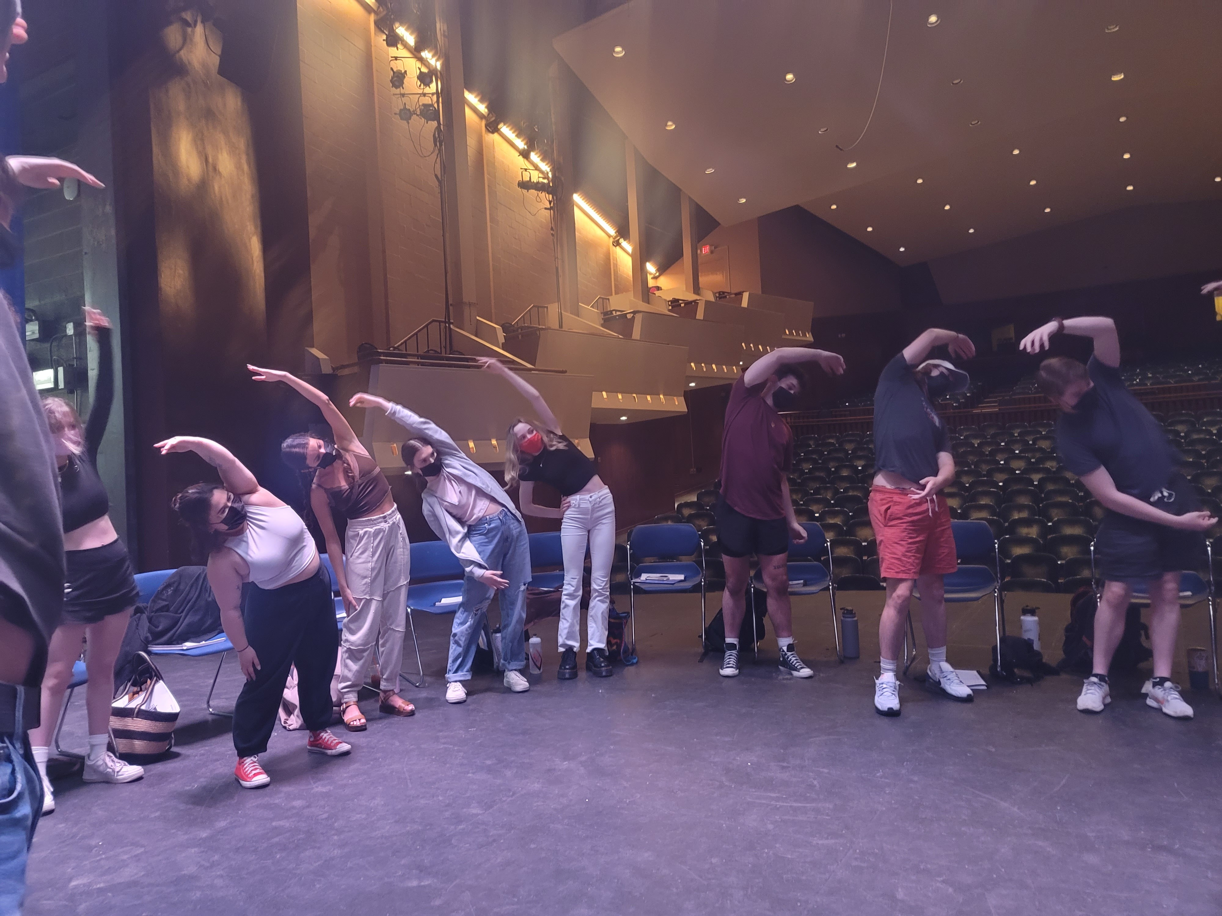 The cast of Footloose stretch for a rehearsal