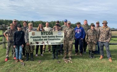 ECOs and youth hunters stand with waterfowl and pheasants they hunted during event