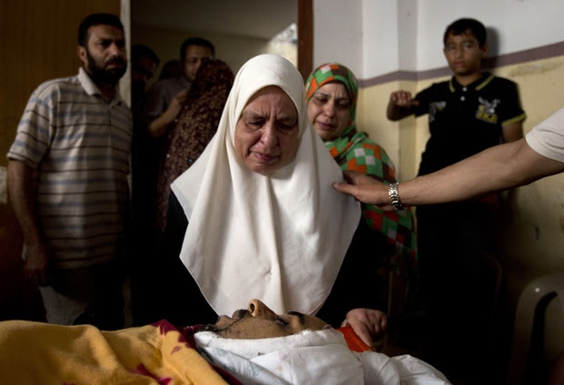 A relative of killed Palestinian doctor Anas Abu al-Kas, 33, mourns over his body during his funeral in the family home in the Jabalia refugee camp, in the northern Gaza Strip.