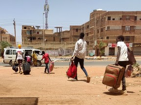TOPSHOT - People board a mini-bus as they evacuate southern Khartoum, on May 14, 2023. War in Sudan has created genuine refugees but some other Sudanese appear to be making false claims in an attempt to gain Canadian citizenship.