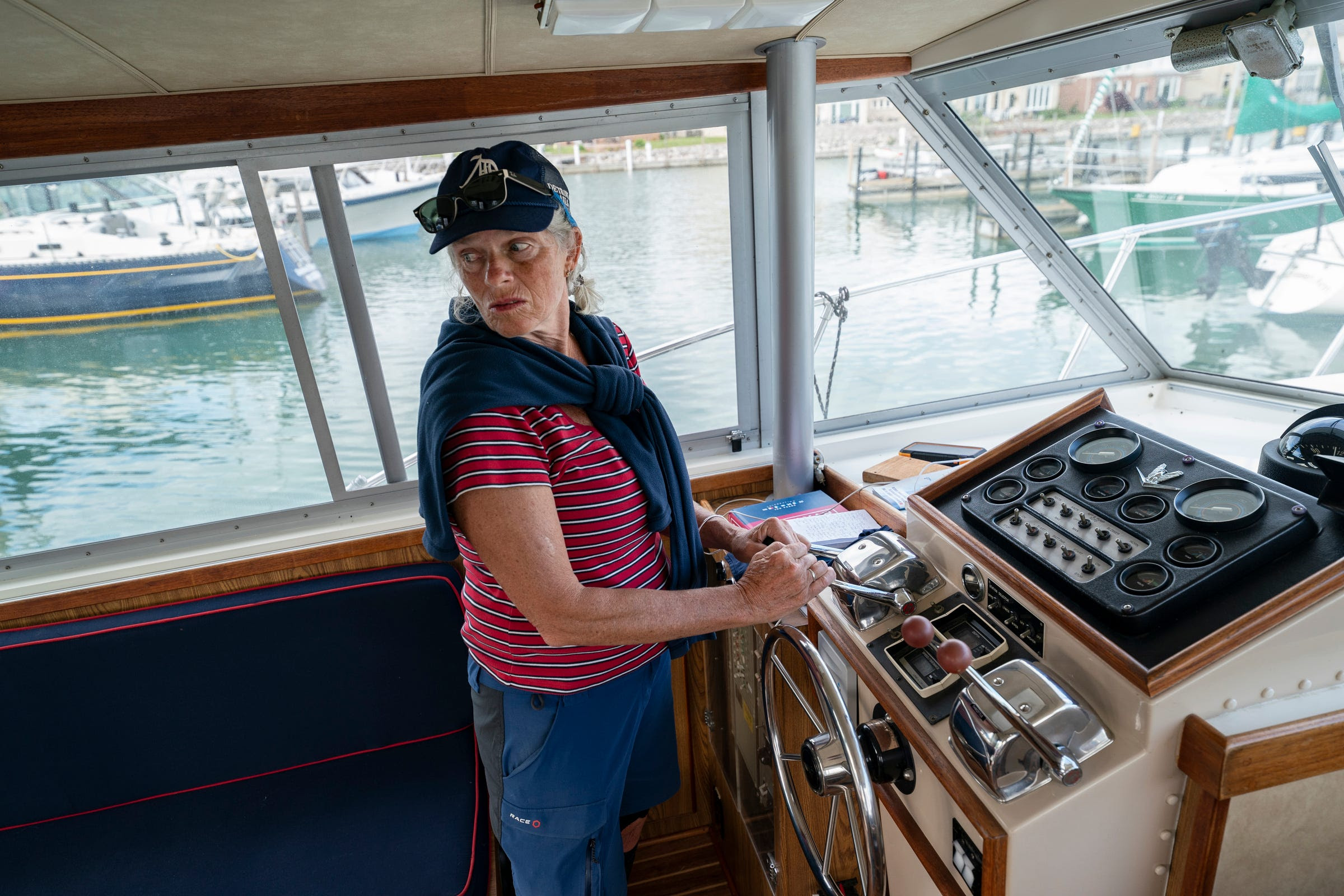 Captain Ann Perrault uses controls to steer the Bertram 33 power boat out of the Grayhaven State Harbor marina on Saturday, June 4, 2022. Perrault and first mate Julion De'Angelo took out a group on a charter tour of the Detroit River.