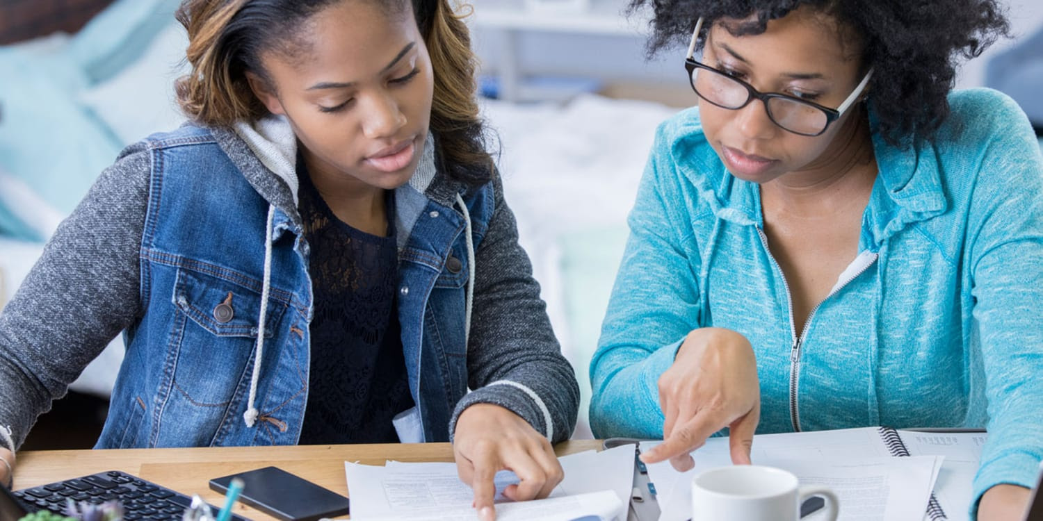 A woman going over papers with her daughter