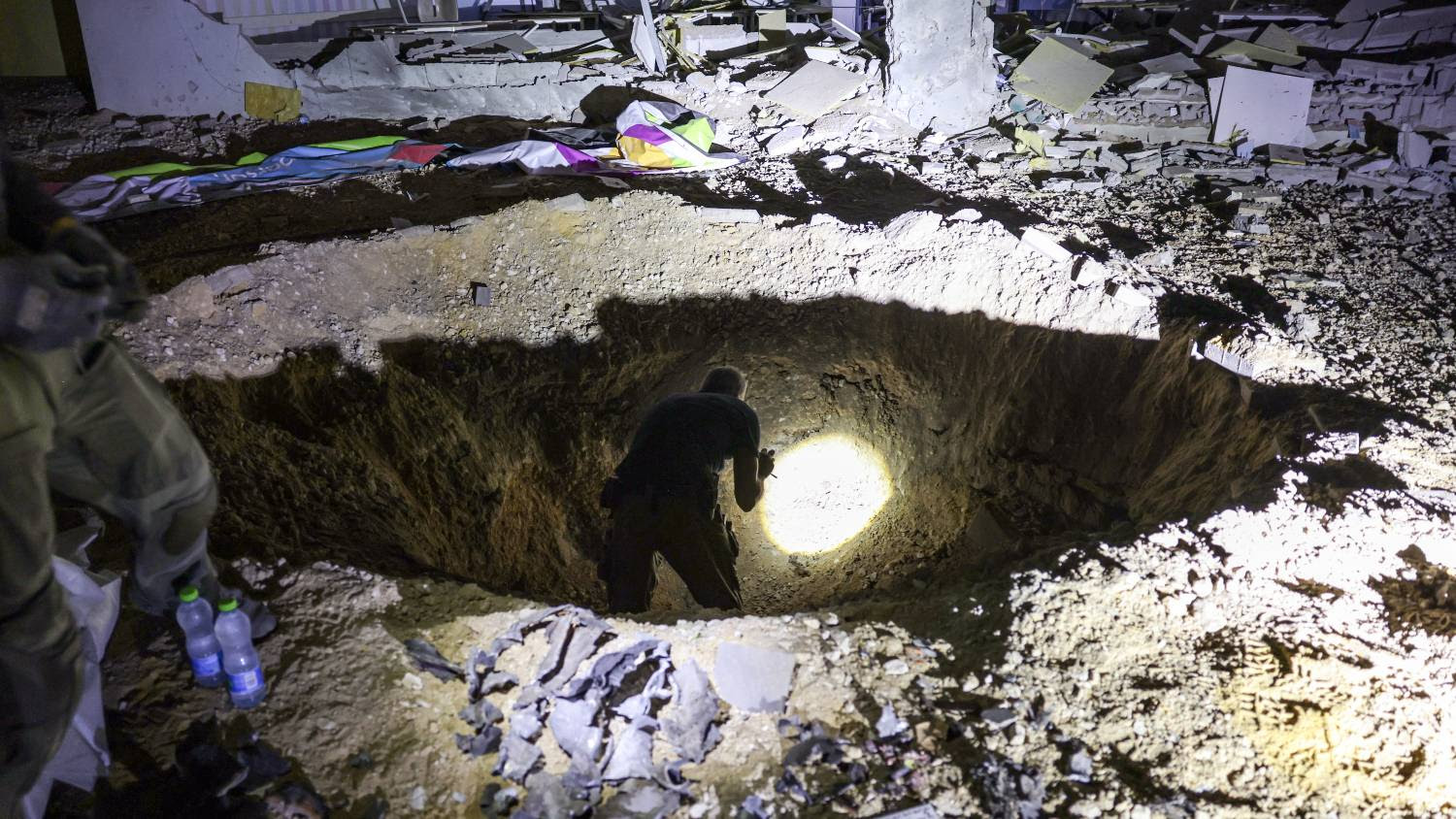 A crater left by an exploded projectile at a heavily-damaged school building in Israel's southern city of Gedera on 1 October 2024.