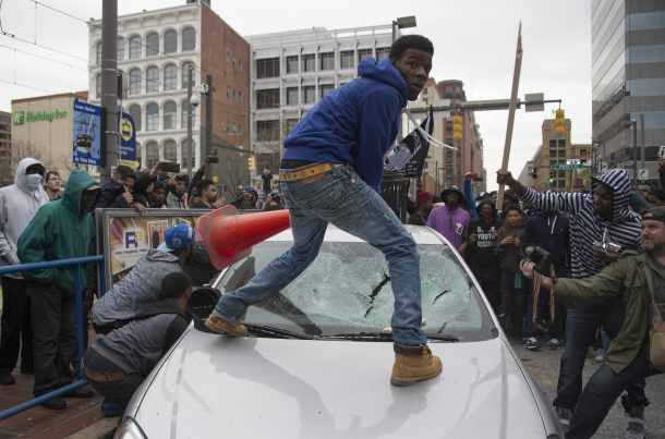 -- AFP PICTURES OF THE YEAR 2015 -- Demonstrators destroy the windshield of a Baltimore Police car as they protest the death Freddie Gray, an African American man who died of spinal cord injuries in police custody, in Baltimore, Maryland, April 25, 2015. Protesters returned to Baltimore's streets Saturday to vent outrage over the death of Gray on April 12. AFP PHOTO/JIM WATSON