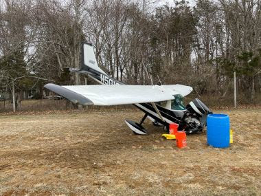 small plane that crashed in a field, the nose of the plane shows damage
