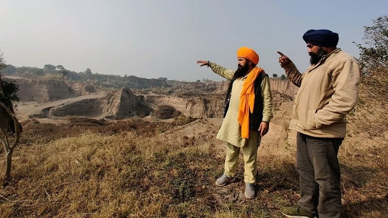 Activist Ram Singh (L) with Sukhdev Singh (R) pointing to an illegal quarry near his village | Urjita Bhardwaj | ThePrint