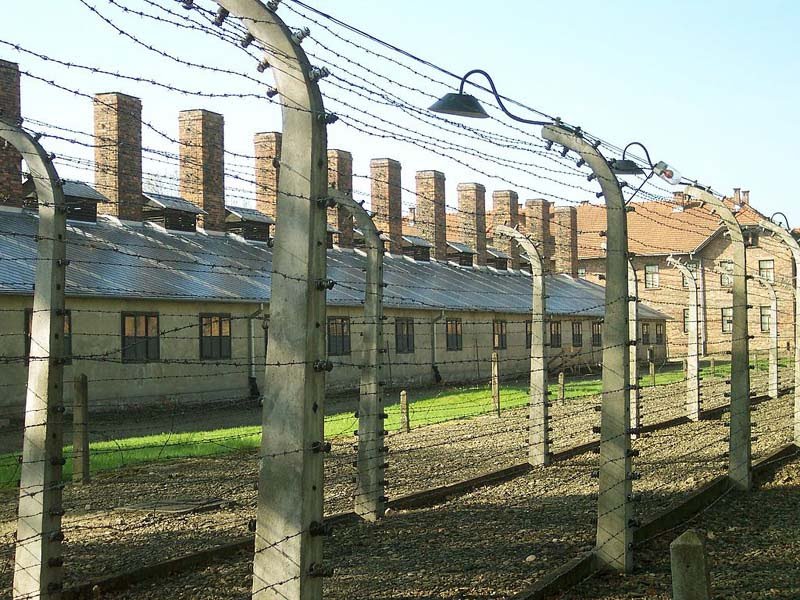 Barbed wire perimeter fencing near by the entrance to the German death camp Auschwitz I in Poland. Note the electrical insulators on the concrete fence-posts.