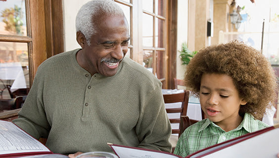 Grandfather and grandson reading a menu