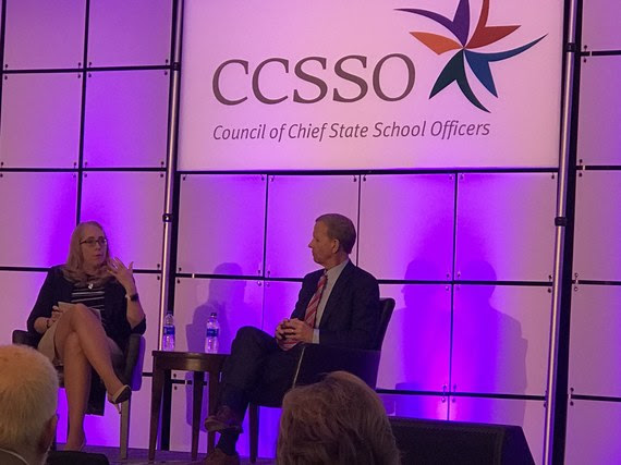 Frank Brogan talks with CCSSO Executive Director Carissa Miller on a stage underneath a large sign that reads CCSSO Council of Chief State School Officers.