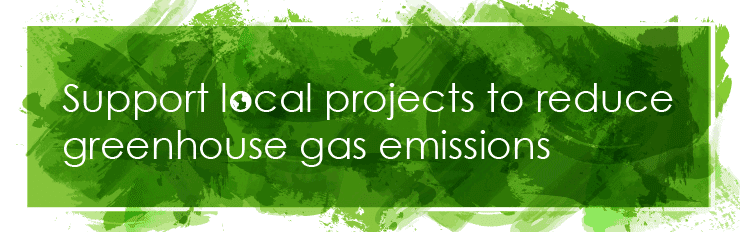 Bright green brushstrokes overlaid with white text, which reads: Support local projects to reduce greenhouse gas emissions.