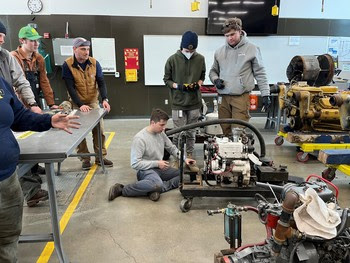 Photo of people working on a diesel engine in a classroom setting