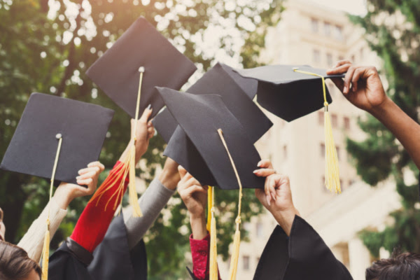 Graduate throwing hats into the air.