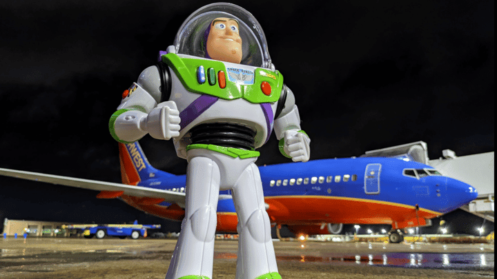 Buzz outside with a Southwest plane behind him