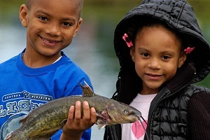 smiling young boy and girl holding a fish