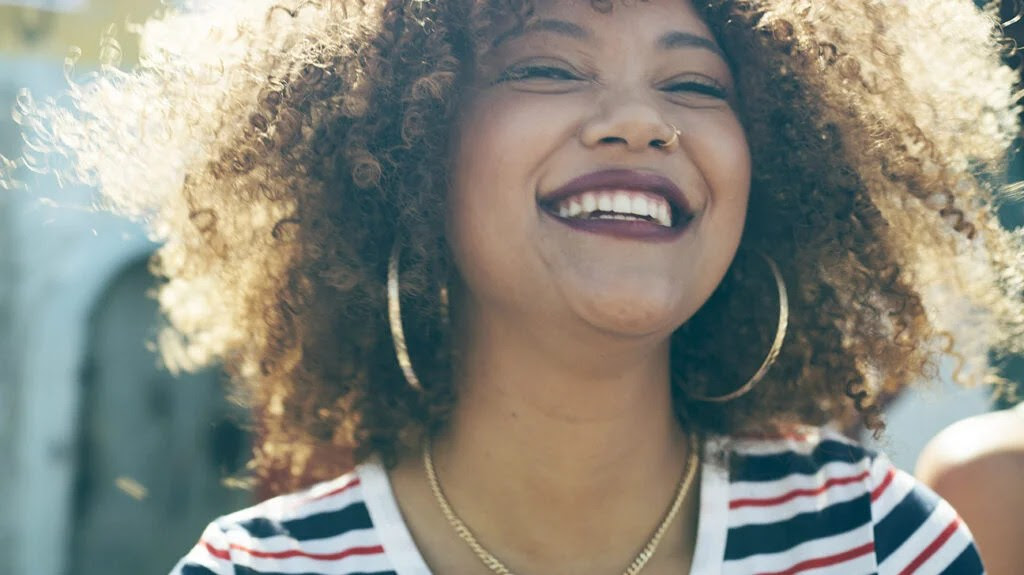 A woman with curly hair smiling