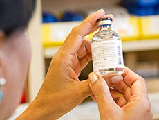 pharmacist holding drug vial