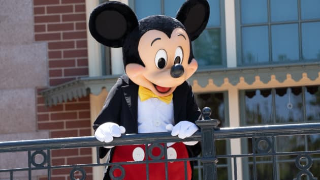 Mickey Mouse stands in front of a building 