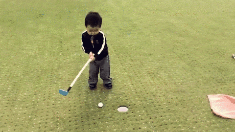 Asain boy missing a mini-golf put shot and then throwing a tantrum GIF