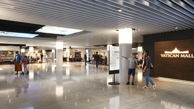 Imagen del interior donde se ve el logo del centro comercial, la silueta de la Basílica de San Pedro, sede de la Iglesia Católica.