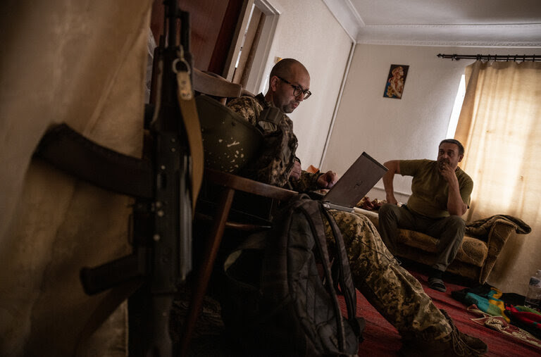 Anton Filatov, left, a Ukrainian film critic turned soldier, in an abandoned house near the front in Donbas in August. He has kept writing throughout the war, though his subject has changed.