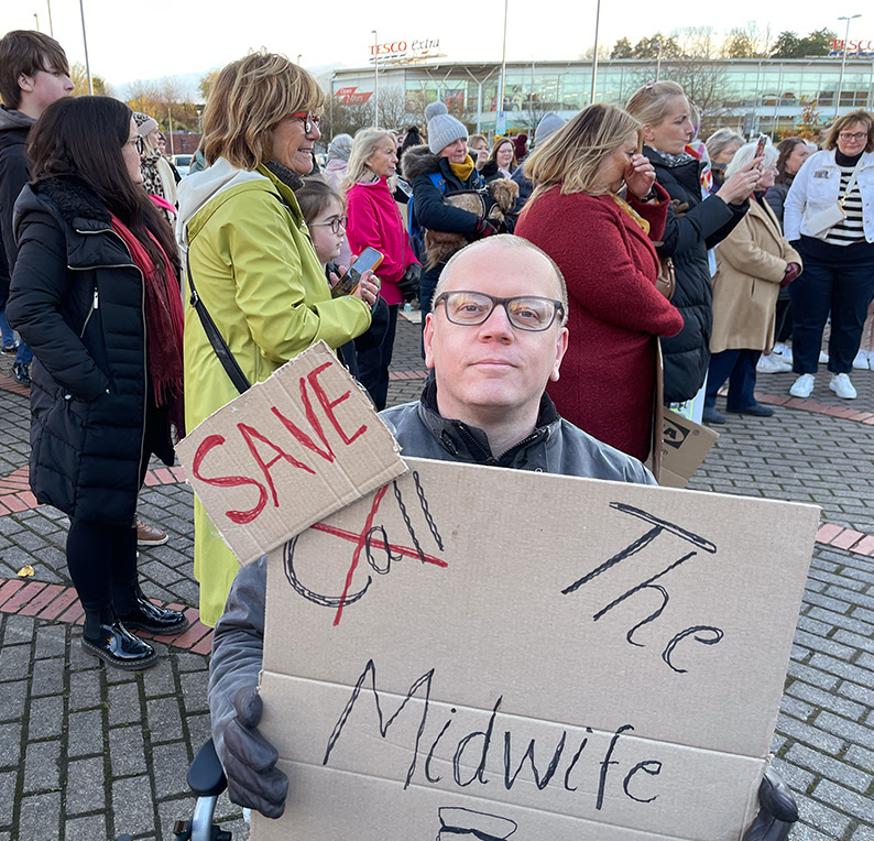 Cllr Martyn hurt at a vigil holding a 'Save the Midwives' placard