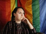 Destiny Clark of Odenville, Ala., sits in front of a pride flag for a portrait. Three transgender women including Clark have filed a lawsuit challenging Alabama&#39;s requirement for a person to show proof of sex-altering surgery in order to change the gender designation on their driver&#39;s license. (AP Photo/Brynn Anderson, File)